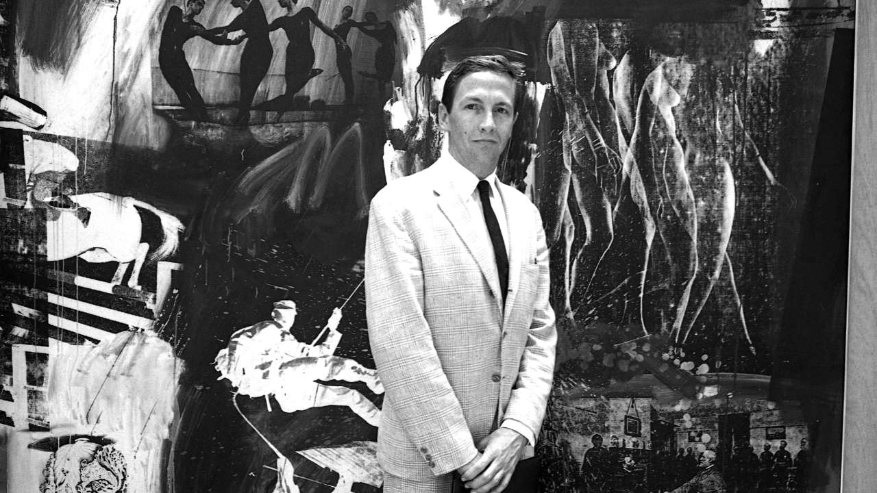 a man in a suit in front of a painting